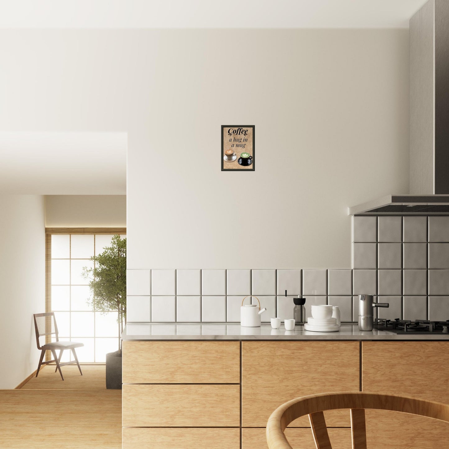 Eingerahmtes Bild mit der Überschrift: "Coffee" und dem Titel: "a hug in a mug" mit zwei Tassen Kaffee auf einem Beigen Hintergrund über einer Küchenzeile hängend