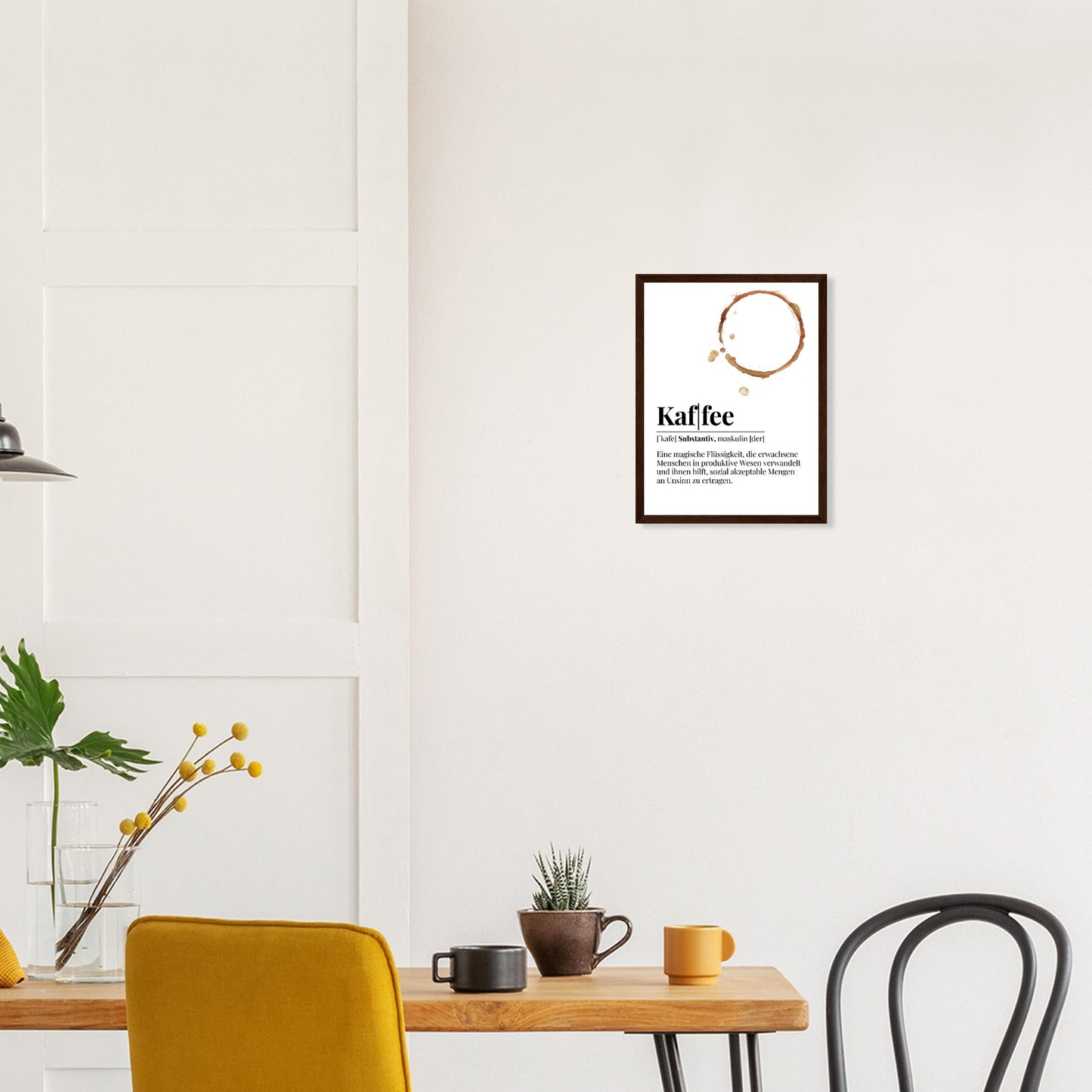Ein Bild im Holzrahmen mit der Definition von Kaffee mit einem frechen Spruch als Definition. Mittig im Bild befindet sich ein Kaffee Tassenabdruck . Das bild Hängt über einem Essenstisch