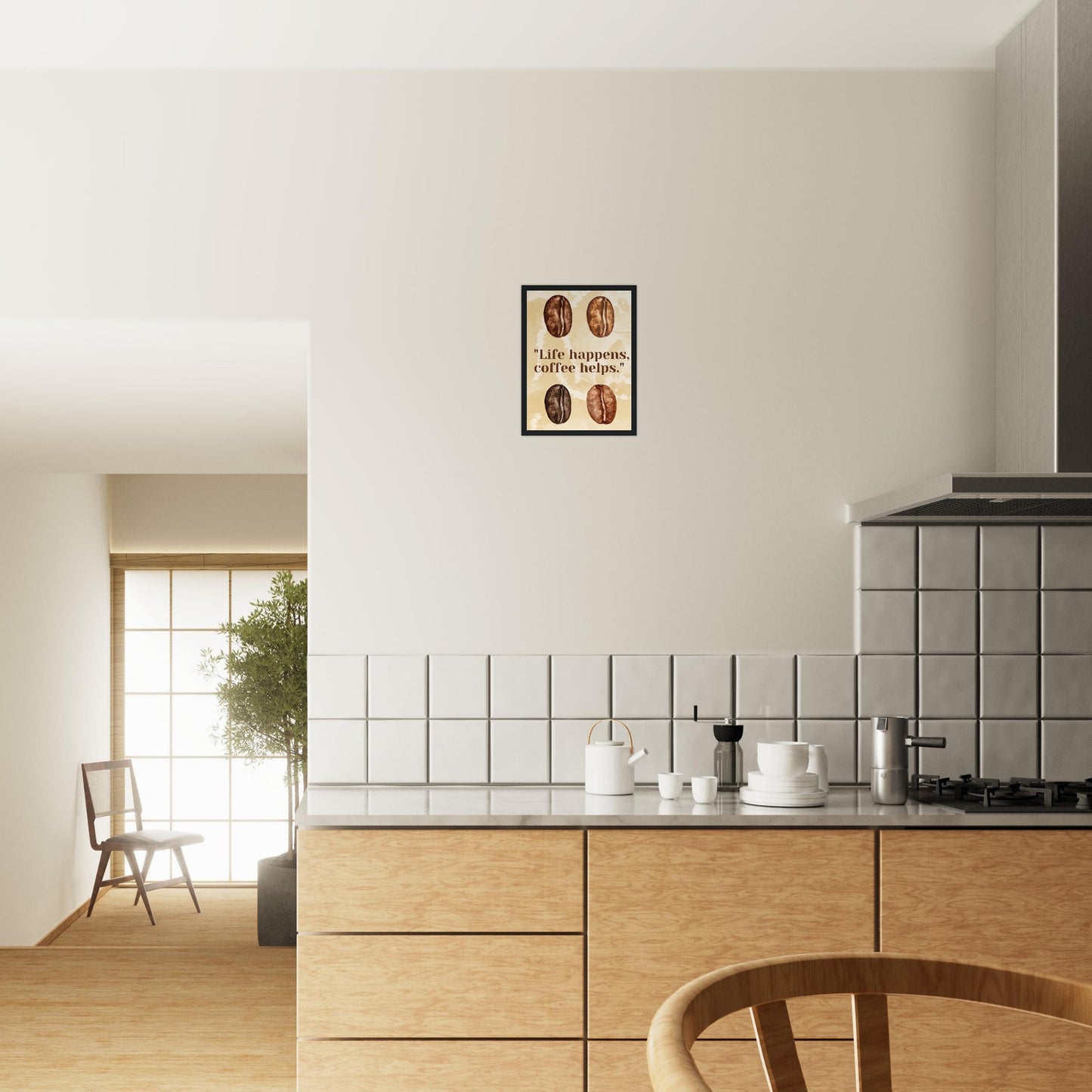 Ein Bild in einem Schwarzen Rahmen mit einem beigen Wasserfarbenhintergrund. In der Mitte des Bildes steht: "Life happens, coffee helps.". Sowohl über als auch unter dem Text sind jeweils Zwei mit Wasserfarben gemalten Kaffeebohnen die den unterschiedlichen Röstungsgrad repräsentieren soll. Das Bild hängt über einer Küche.