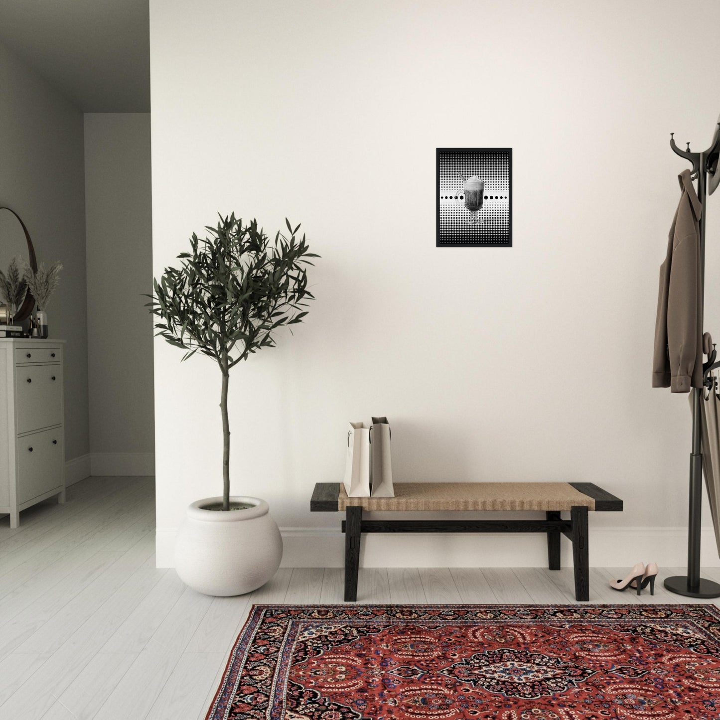 Bild im schwarzem Rahmen mit einem Schwarz weißem Motiv aus schwarzen punkten auf einem weißen Untergrund gepaart eines Schwarzweiß Foto eines Cappuccino an der wand eines Eingangsbereich eines Hauses.